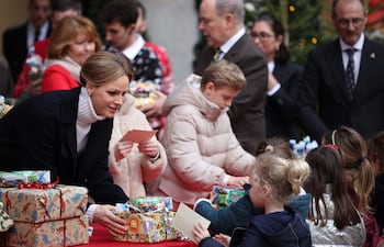 La princesa Charlene de Mónaco, junto al príncipe Jacques y la princesa Gabriella, y el príncipe Alberto II de Mónaco, distribuyeron regalos a los niños. (Valery HACHE / AFP)