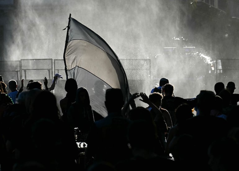 Manifestantes se enfrentan a la policía antidisturbios durante una protesta frente al Congreso, donde se debate la reforma laboral del presidente argentino Javier Milei, en Buenos Aires el 19 de febrero de 2026. (Photo by Luis ROBAYO / AFP)
