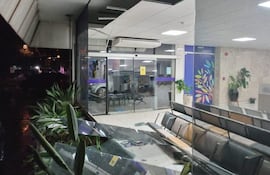 Interior del Instituto Nacional del Cáncer dañado, con muebles desordenados y vidrio roto en una sala de espera oscurecida.