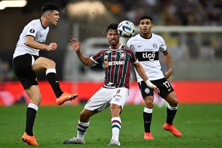 Martinelli (c), jugador de Fluminense, es presionado por Junior Barreto (d) y Marcos Gómez, futbolistas de Olimpia, en el partido de los cuartos de final de la Copa Libertadores 2023 en el estadio Maracaná, en Río de Janeiro, Brasil.