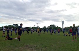 Grupo de jóvenes entrenando, mientras escuchan al entrenador.