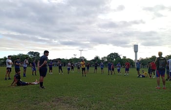 Grupo de jóvenes entrenando, mientras escuchan al entrenador.