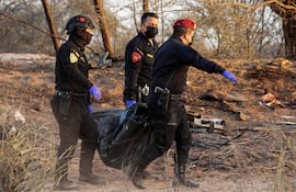 Rescatistas trasladan el cuerpo de una de las víctimas del accidente aéreo del pasado sábado en Nazca.