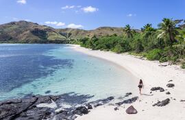 Una mujer camina por las playas de la isla Nacula. Paraíso tropical y desolado, fue el escenario de la famosa película La laguna azul en 1980. Un destino turístico fabuloso en Yasawa, Fiyi.