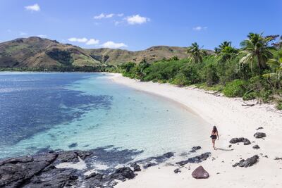 Una mujer camina por las playas de la isla Nacula. Paraíso tropical y desolado, fue el escenario de la famosa película La laguna azul en 1980. Un destino turístico fabuloso en Yasawa, Fiyi.