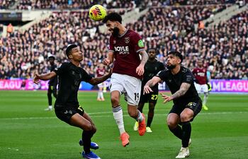 El delantero hispano-brasileño del West Ham United, Pablo Felipe (C), salta para cabecear el balón por encima del defensa mozambiqueño Reinildo Mandava, y el paraguayo Omar Alderete, durante el partido de la Premier League entre el West Ham United y el Sunderland en el London Stadium, en el este de Londres.