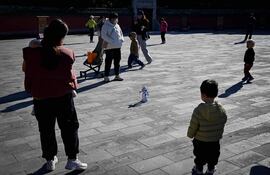 Imagen ilustrativa. Pobladores de Pekín observan a un robot en un parque público. (AFP)