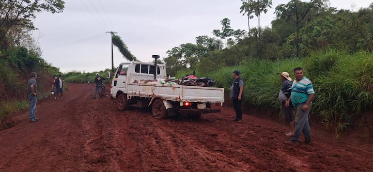 Pobladores unen fuerza para sacar a un camioncito que quedó empantanado en la Ruta Py 21.
