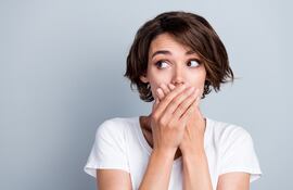 Mujer se tapa la boca.