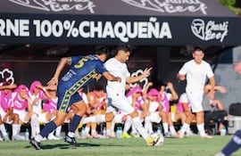 El volante ofensivo de Libertad, Federico Pachi Carrizo intenta meter el pase ante la marca del mediocampista Nelson Ariel Gauto del Sportivo Trinidense.