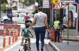 En la mañana de domingo, un niño acompañado por una adulta aprovecha el tramo de la bicisenda que corre sobre la calle Palma para andar en su bicicleta con rueditas.