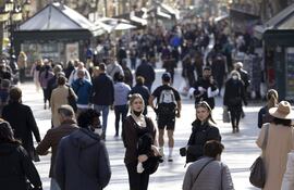 Varias personas pasean por la Rambla de Barcelona,.