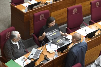 El senador Ignacio Iramain (independiente), Esperanza Martínez (Frente Guasu), quien porta un cartel en apoyo a los adultos mayores, conversan con el presidente del Senado, Basilio "Bachi" Núñez.