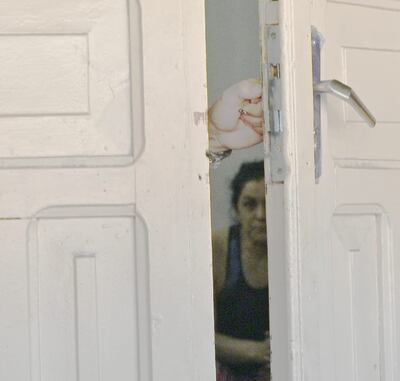 A través de la puerta entreabierta se puede ver a Carmen Villalba esperar la llegada del ataúd con los restos de su hermano Osvaldo Villalba a la cárcel del Buen Pastor.