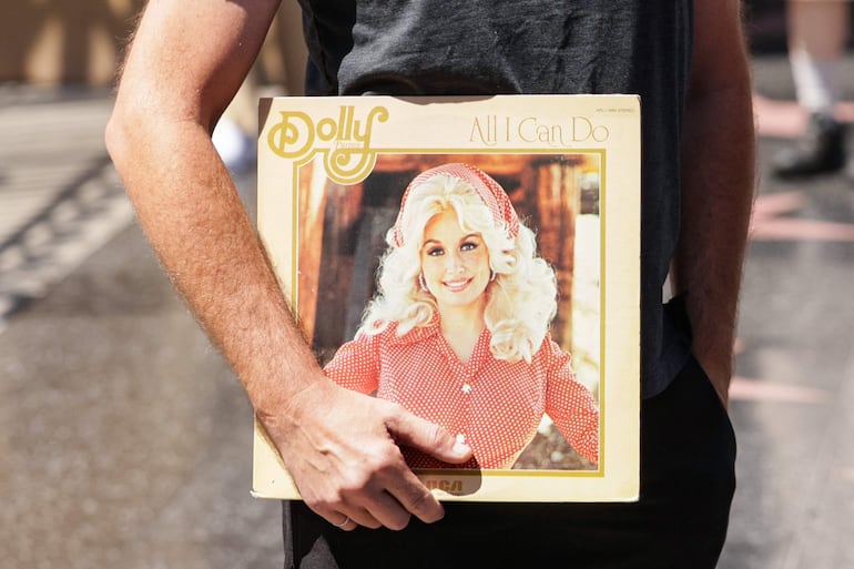 Un fan sostiene uno de los álbumes de vinilo de Dolly Parton frente a su estrella en el Paseo de la Fama. EFE/EPA/CHRIS TORRES