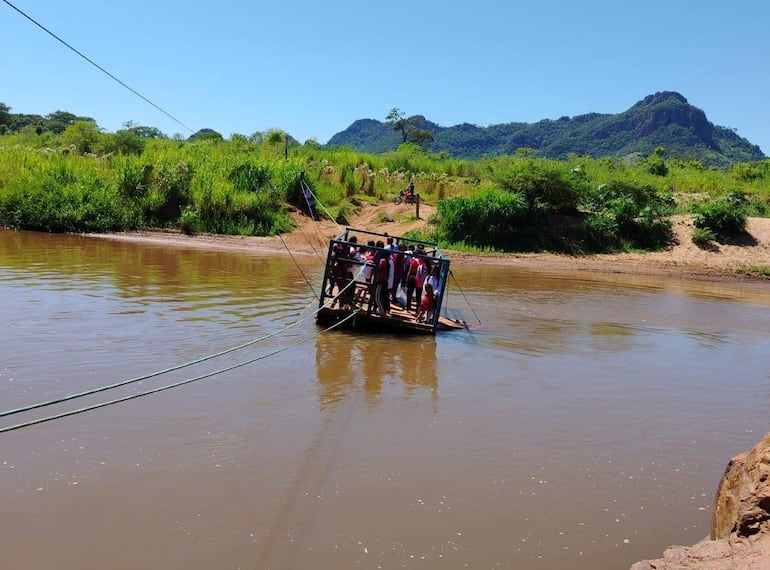 Niños de la Escuela Indígena Pikykua, cruzan el río Aquidabán en precaria balsa para llegar a la institución en Amambay.