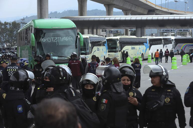 Integrantes de la Secretaría de Seguridad de México bloquean el paso de buses donde viajan estudiantes de Ayotzinapan que se dirigen al Zócalo para manifestarse junto a la Coordinación Nacional de Trabajadores de la Educación (CNTE) este lunes, en el peaje de Tlalpan, al sur de la Ciudad de México (México).