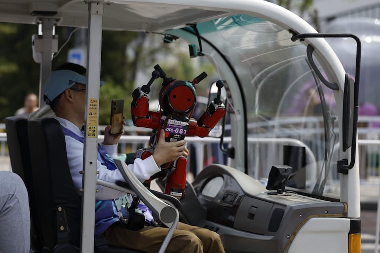 Un robot humanoide Mini Pi saluda con las manos desde un automóvil durante la segunda Beijing E-Town Half Marathon and Humanoid Robot Half Marathon en Beijing, China, el 19 de abril de 2026.