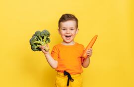 Niño feliz con vegetales.