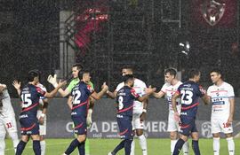 Los jugadores de Nacional y Cerro Porteño realizan el saludo protocolar en la previa del partido por la fecha 18 del torneo Clausura 2025 de la Primera División de Paraguay en el estadio Arsenio Erico, en Asunción, Paraguay.