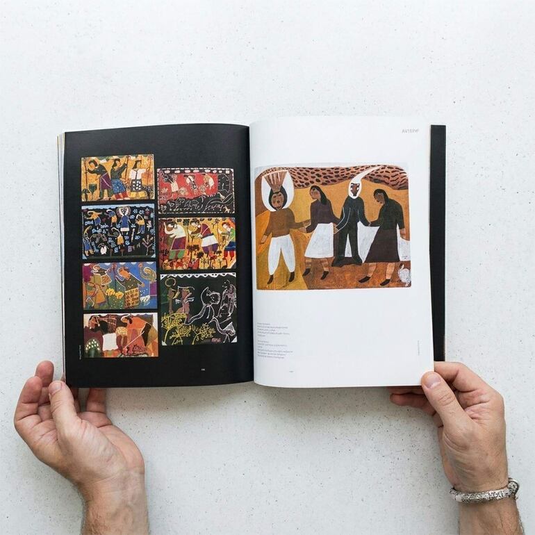 Libro abierto en manos, mostrando ilustraciones vibrantes de figuras humanas en un ambiente artístico.