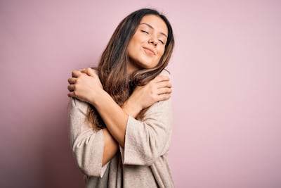 Una mujer se abraza a sí misma.