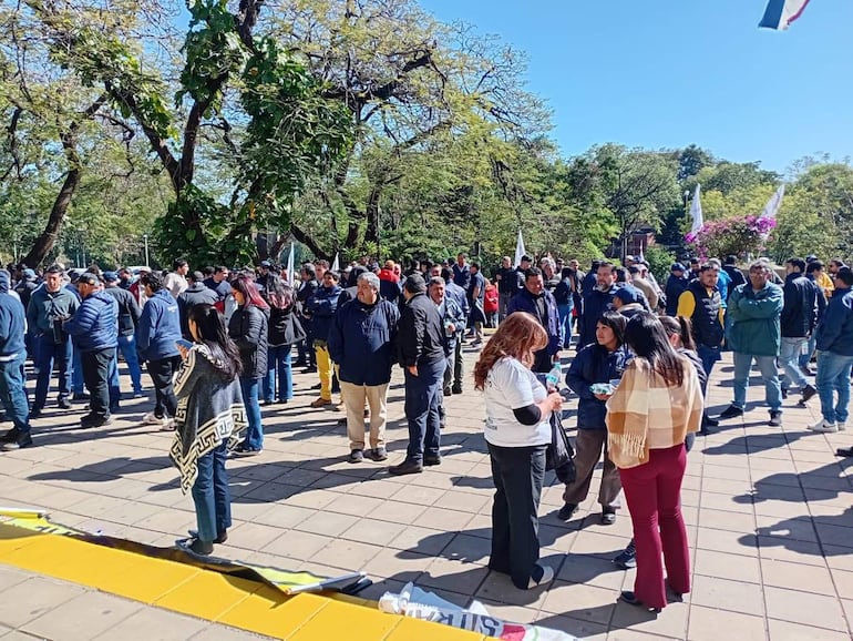Grupo de mujeres y hombres en protestas, con expresiones de felicidad y tranquilidad, rodeados de árboles en un ambiente diurno.