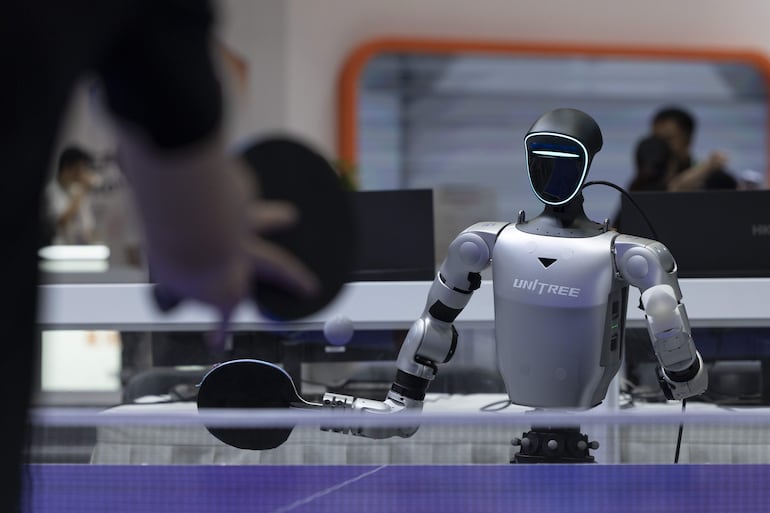 Un robot humanoide juega al tenis de mesa en el puesto de Unitree durante la Conferencia Mundial de Robótica 2026, en Pekín, China, el 19 de agosto de 2026.
