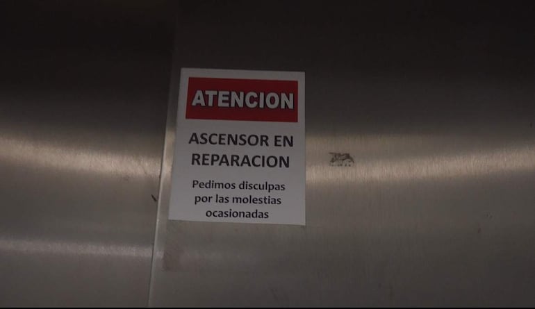 Cartel rojo y blanco en metal que indica el ascensor en reparación en el IPS, sin personas visibles.