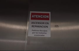 Cartel rojo y blanco en metal que indica el ascensor en reparación en el IPS, sin personas visibles.