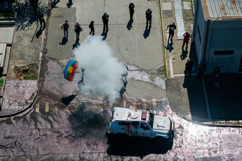 Esta vista aérea muestra a manifestantes enfrentándose a la policía antidisturbios durante una marcha en memoria de las víctimas de la dictadura de Augusto Pinochet (1973-1990) en Santiago, el 6 de septiembre de 2026. (Photo by Javier Torres / AFP)