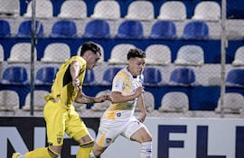 El delantero del Sportivo Luqueño, Kevin Pereira intenta superar la marca del defensor de Recoleta FC, Nicolás Marotta.