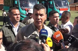 Santiago Peña Palacios en ropa informal, frente un micrófono, rodeado de hombres y una mujer atentos en ambiente al aire libre.