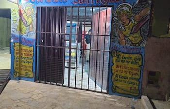Fachada de Bodega San Miguel con murales coloridos; entrada cerrada y figura en uniforme al fondo.