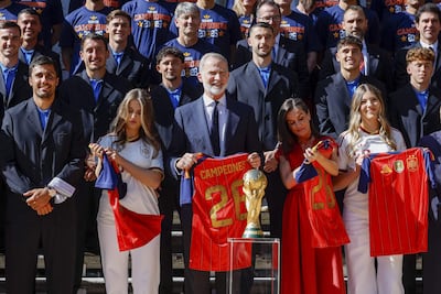 Los reyes Felipe VI y Letizia, la princesa Leonor y la infanta Sofía, felices con las camisetas de los campeones mundiales en sus manos, en los jardines del Palacio de la Zarzuela. (EFE/Daniel González)