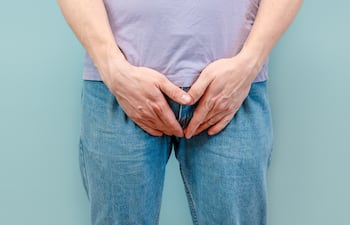 Hombre tiene las manos entre las piernas.