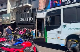 Grupo de personas reunido en la acera, algunos con cámaras, observan un autobús y motocicletas en el Mercado 4.