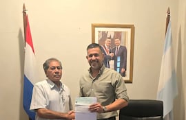 Mario Dos Santos entrega un cheque aporte a Marcos Ibarrola, de la comision organizadora de festejos patronales de Paso de Patria