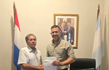 Mario Dos Santos entrega un cheque aporte a Marcos Ibarrola, de la comision organizadora de festejos patronales de Paso de Patria