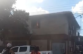 Se observa a través de la ventana como las llamas van tomando la casa ubicada en el segundo piso.