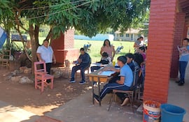 Alumnos de la Escuela Básica Nº 1653 María Auxiliadora de Caaguazú dan clases bajo los arboles del predio de la institución.