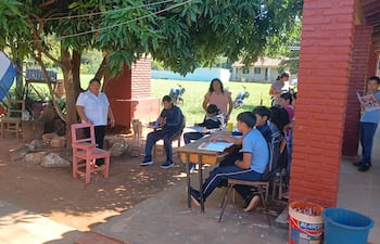 Alumnos de la Escuela Básica Nº 1653 María Auxiliadora de Caaguazú dan clases bajo los arboles del predio de la institución.