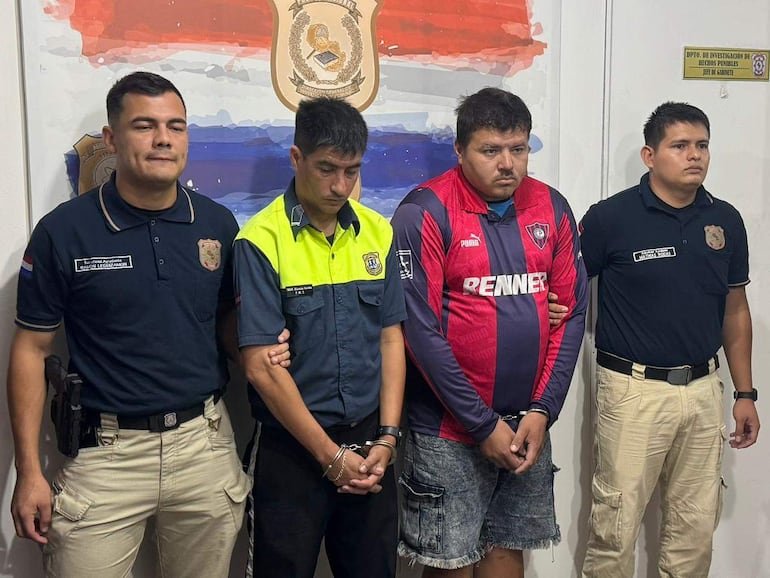 El agente de PMT Nicolas Fariña, vestido de uniforme, junto a Diego Isabelino Vera en camiseta de Cerro Porteño, tras ser detenidos por incidentes en el Superclásico.