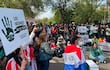 Protesta con personas sosteniendo carteles, entre ellos uno que dice 'LOS MÉDANOS NO SE TOCAN'. Algunos llevan camisetas rojas y blancas.