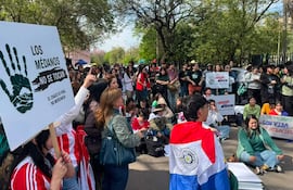 Protesta con personas sosteniendo carteles, entre ellos uno que dice 'LOS MÉDANOS NO SE TOCAN'. Algunos llevan camisetas rojas y blancas.