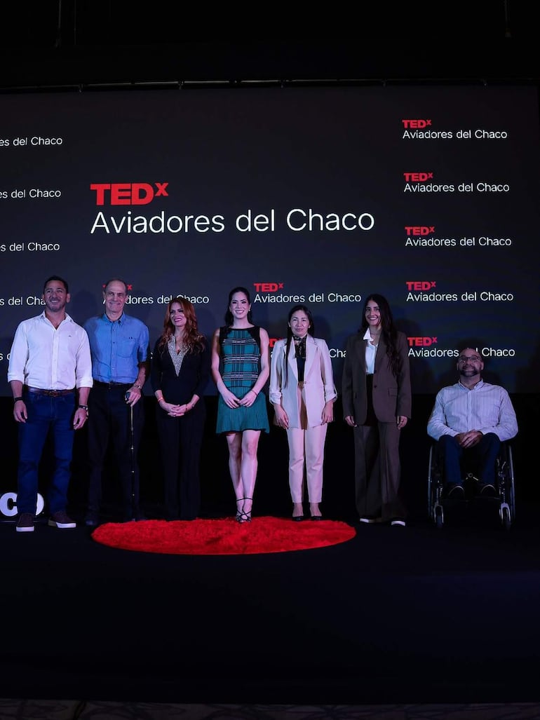 Giselle Ramírez y cuatro personas en el escenario de TEDxAviadores del Chaco, todos sonrientes y alineados para la presentación.