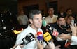 Santiago Peña, con camisa blanca, habla seriamente rodeado de periodistas y micrófonos, mientras se observa una multitud al fondo.