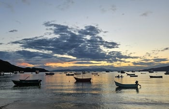 Canoas al atardecer en el mar de dentro, en Canto Grande, Bombinhas, en Santa Catarina, Brasil.