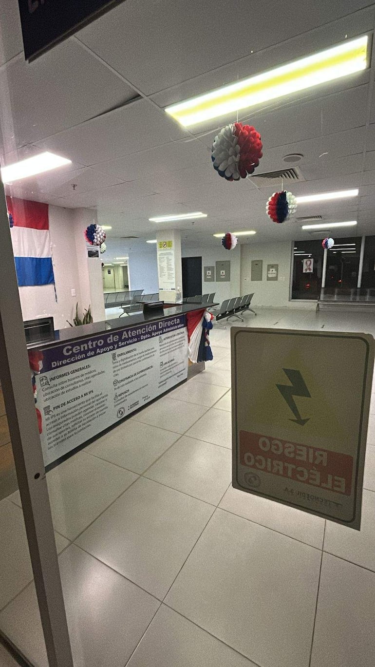Espacio interior del Centro de Atención Directa con mostrador, globos rojos, blancos y azules, sillas vacías en espera.