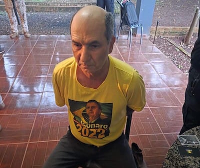 Hombre con camiseta amarilla observa atento en un ambiente cerrado, rodeado de agentes de seguridad.